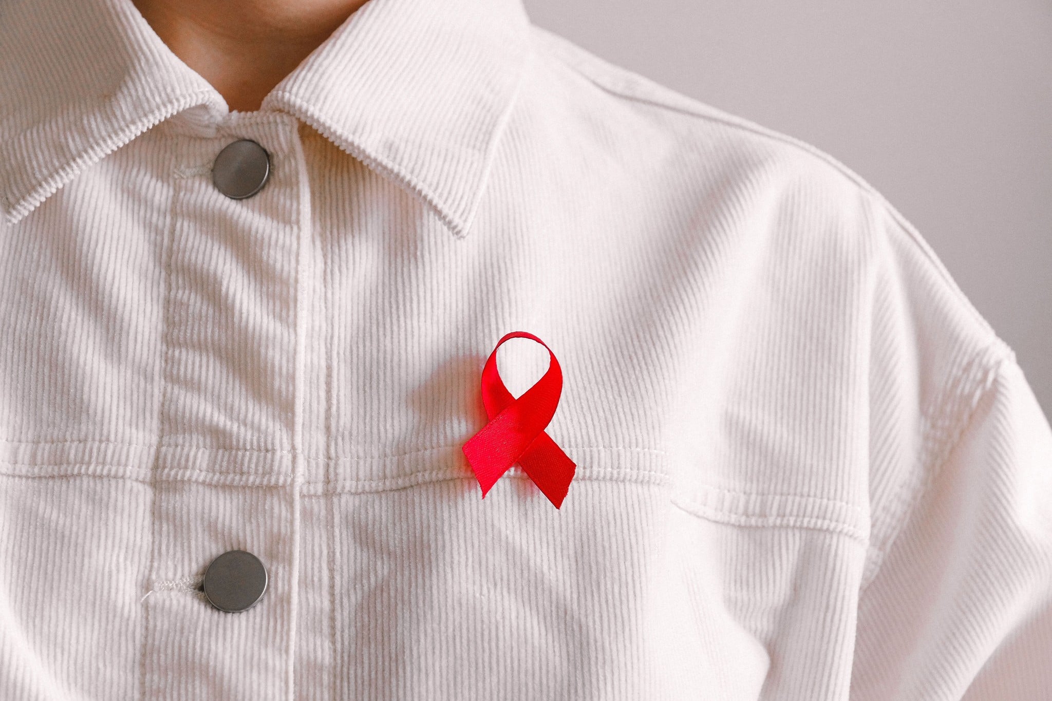 Rood aidslintje op een wit corduroy jasje
